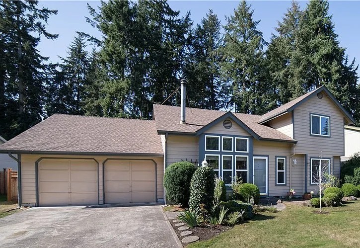 Front of two story house, yard, and driveway.